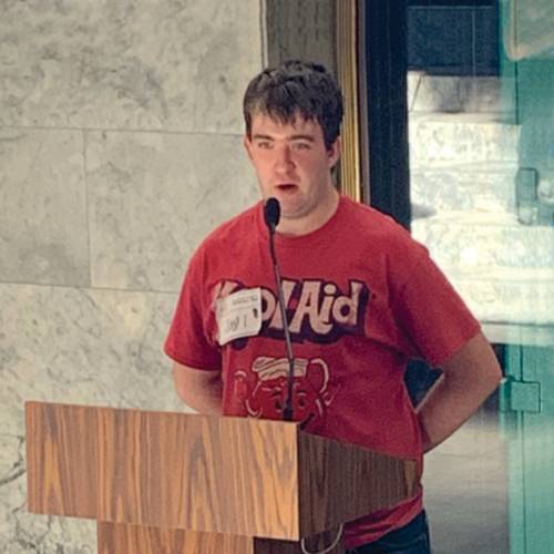 Youth Leadership Summit. The photo shows a student first member speaking at a podium in Olympia. 